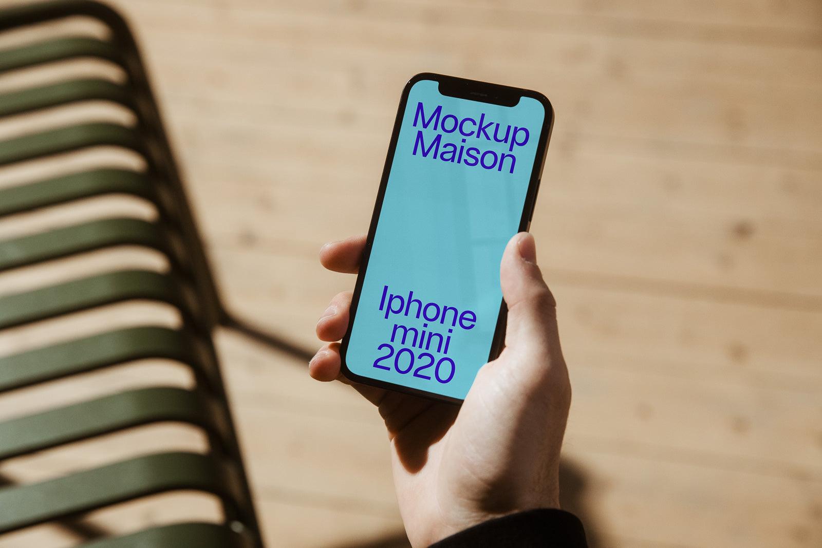 PSD mockup of a person holding an iPhone Mini 2020 with a light blue screen displaying the text "Mockup Maison" and "Iphone mini 2020".