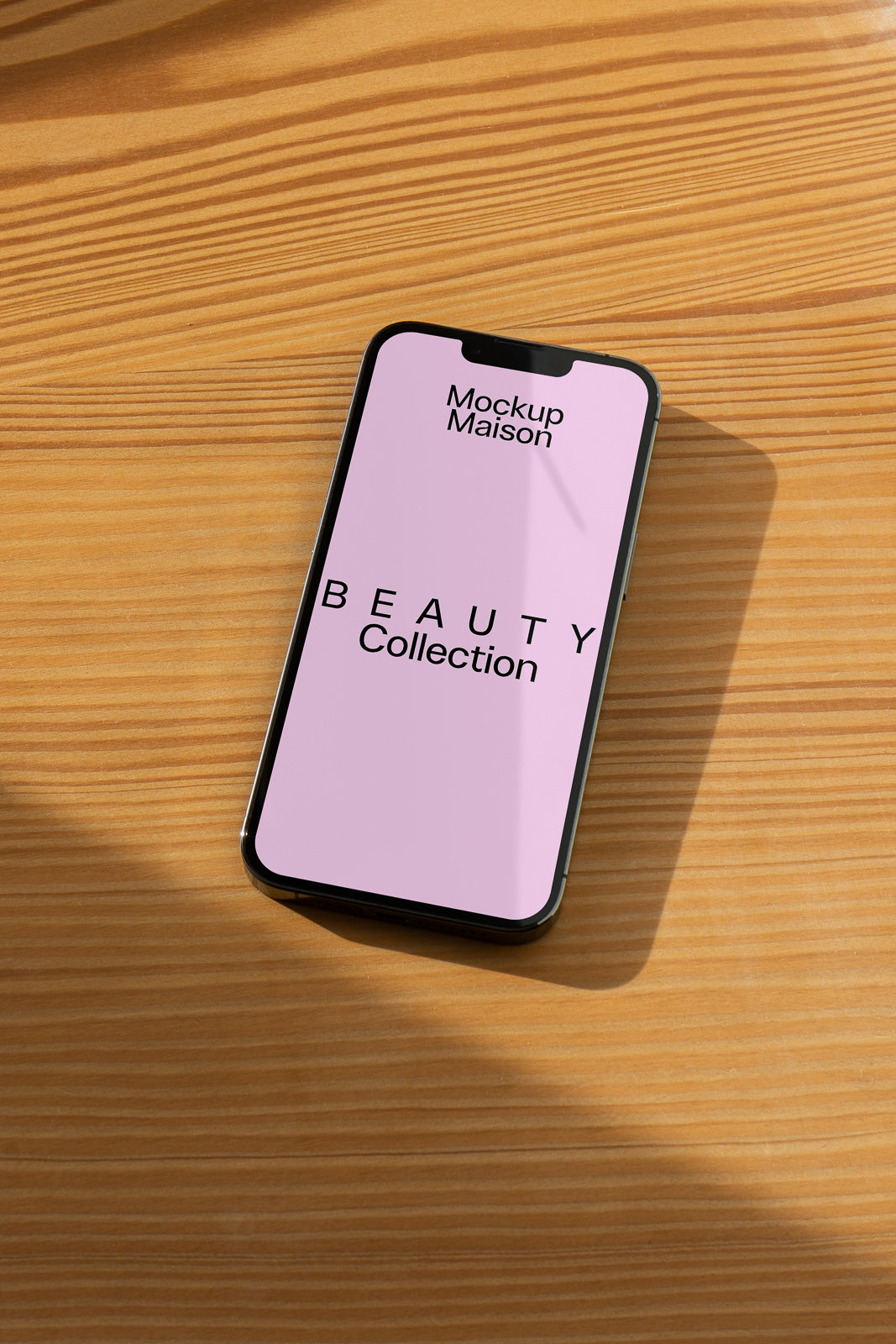 PSD mockup of a smartphone displaying a "Beauty Collection" design on a pink screen, placed on a wooden surface with natural light.