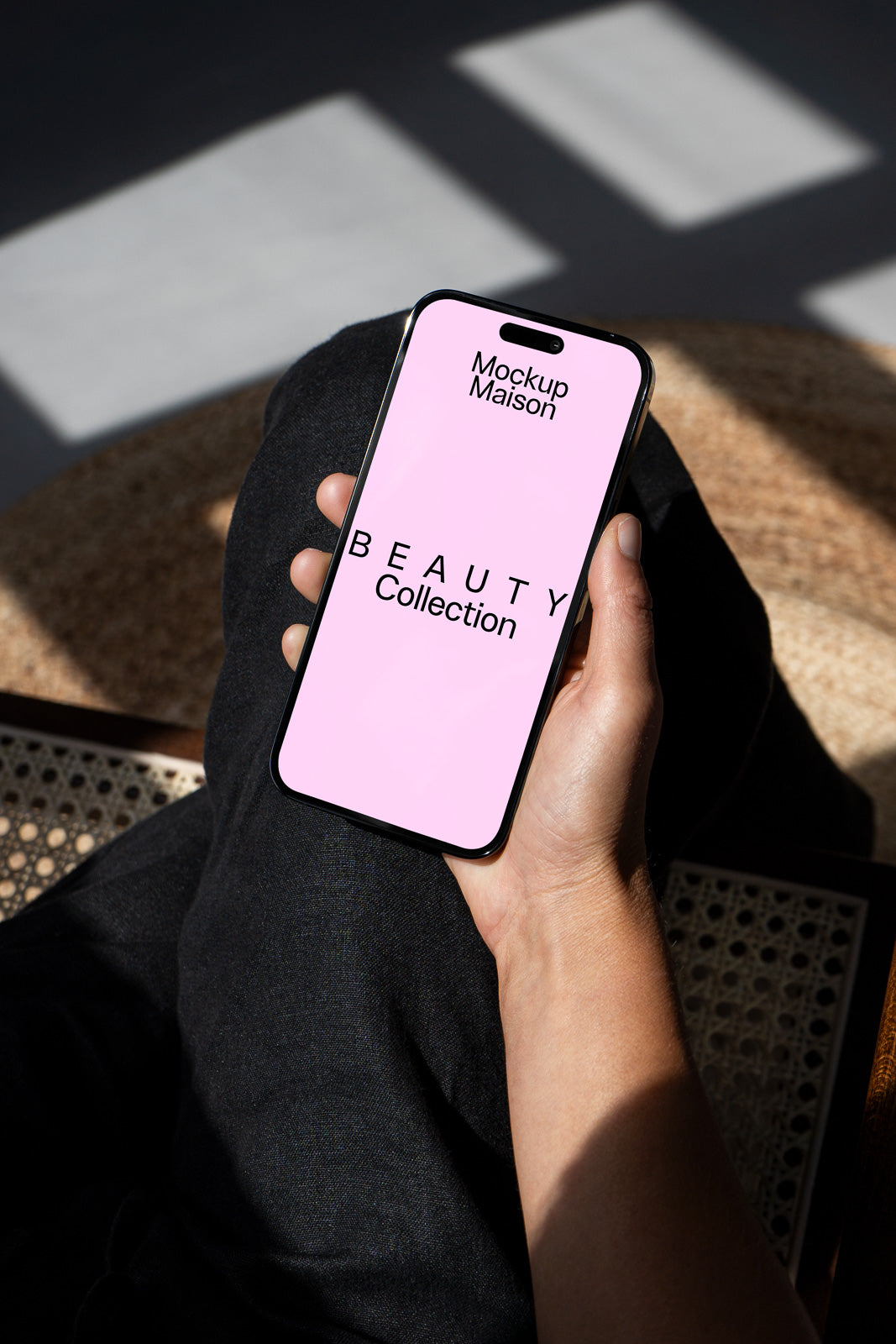 PSD mockup of a smartphone displaying "Mockup Maison" and "Beauty Collection" on a pink screen, held in a hand.