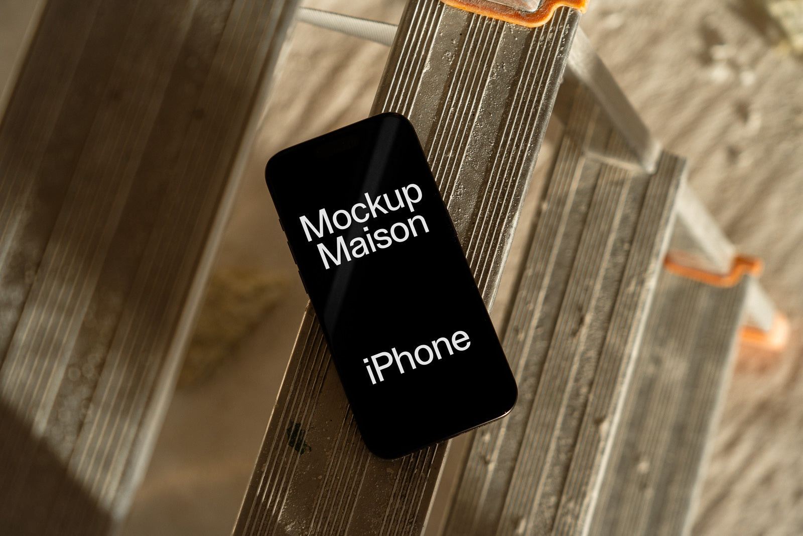 PSD mockup of an iPhone positioned on a metal ladder, displaying "Mockup Maison iPhone" on the screen in a soft, sunlit environment.