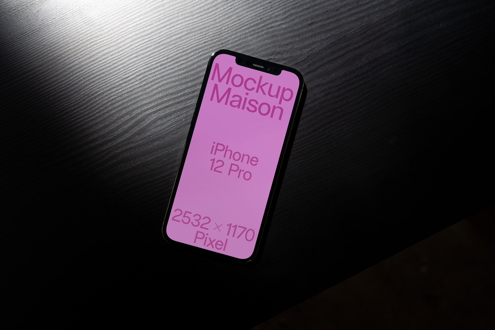 PSD mockup of an iPhone 12 Pro with a pink screen displaying text on a dark wooden surface, showcasing dimensions 2532 × 1170 pixels.