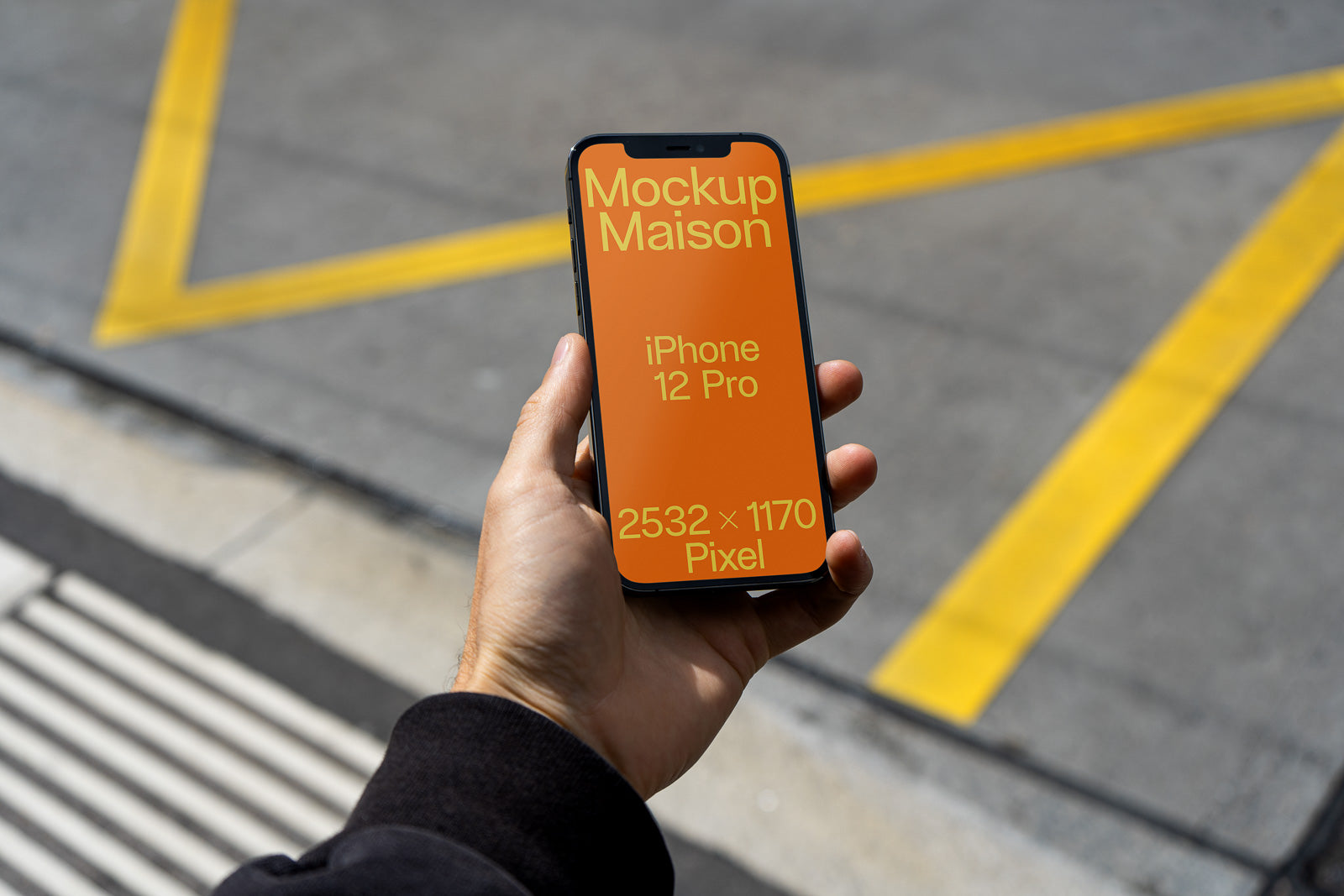 PSD mockup of an iPhone 12 Pro held in a hand, displaying orange screen with text "Mockup Maison" and resolution "2532 x 1170 Pixel".