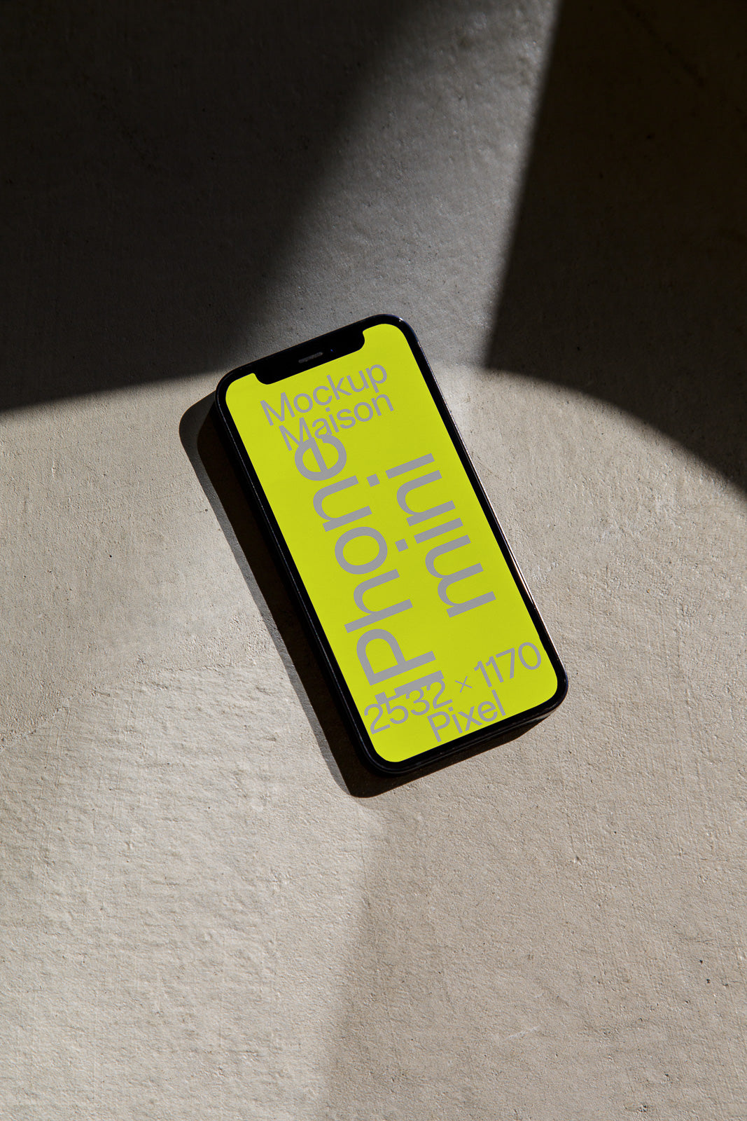 PSD mockup of a smartphone lying on a textured surface, displaying yellow screen with text and specifications like "Phone mini" and dimensions "2532 x 1170 Pixel."