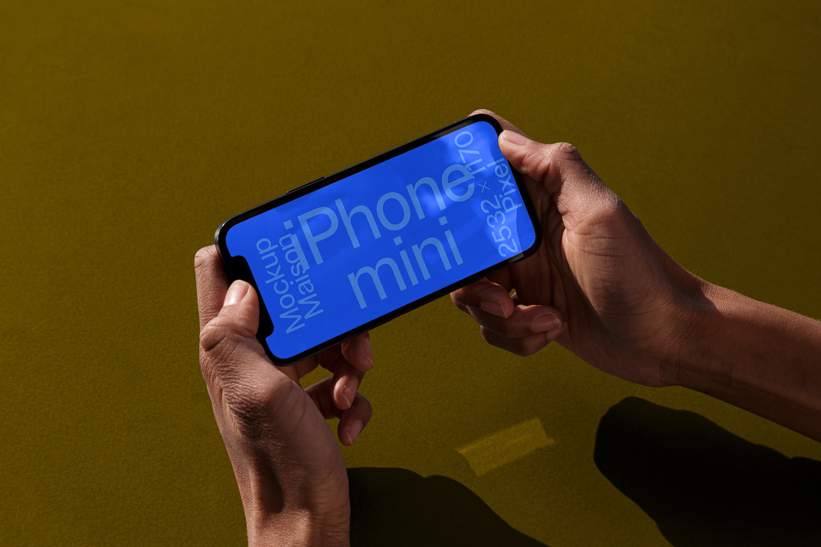 PSD mockup of a smartphone held horizontally by two hands displaying text on a blue screen with dimensions 2532 x 1170 pixels.