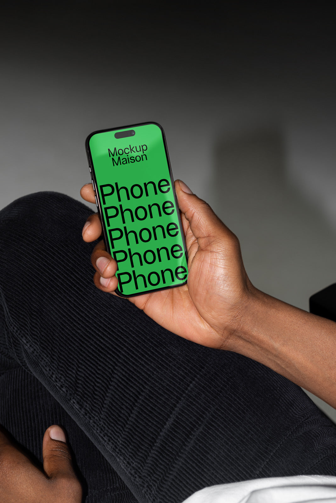 PSD mockup of a smartphone held in hand, displaying a green screen with the words "Mockup Maison" and "Phone" repeated, against a dark background.
