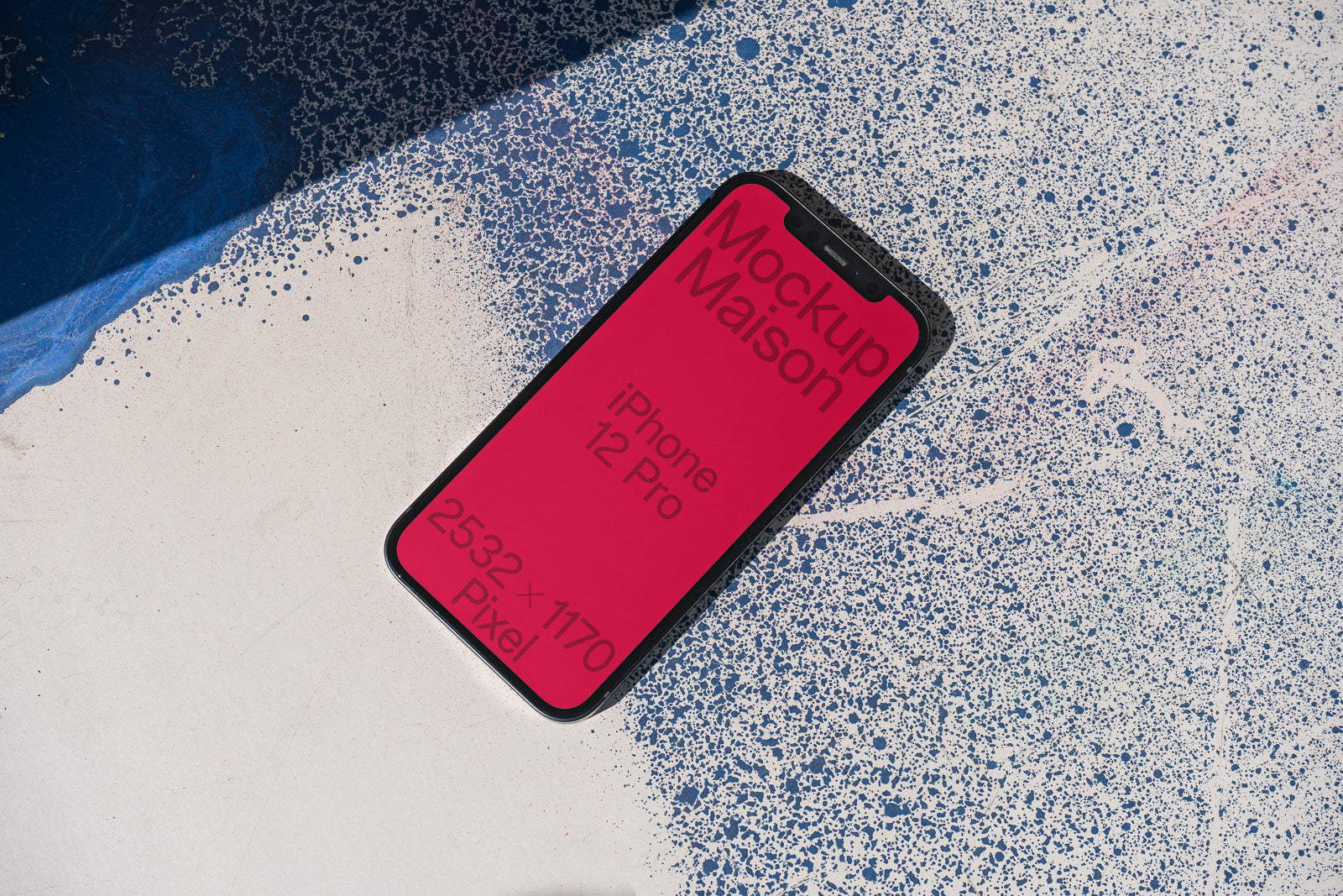 PSD mockup of an iPhone 12 Pro with a pink screen displaying text on a textured background of blue and white speckles.
