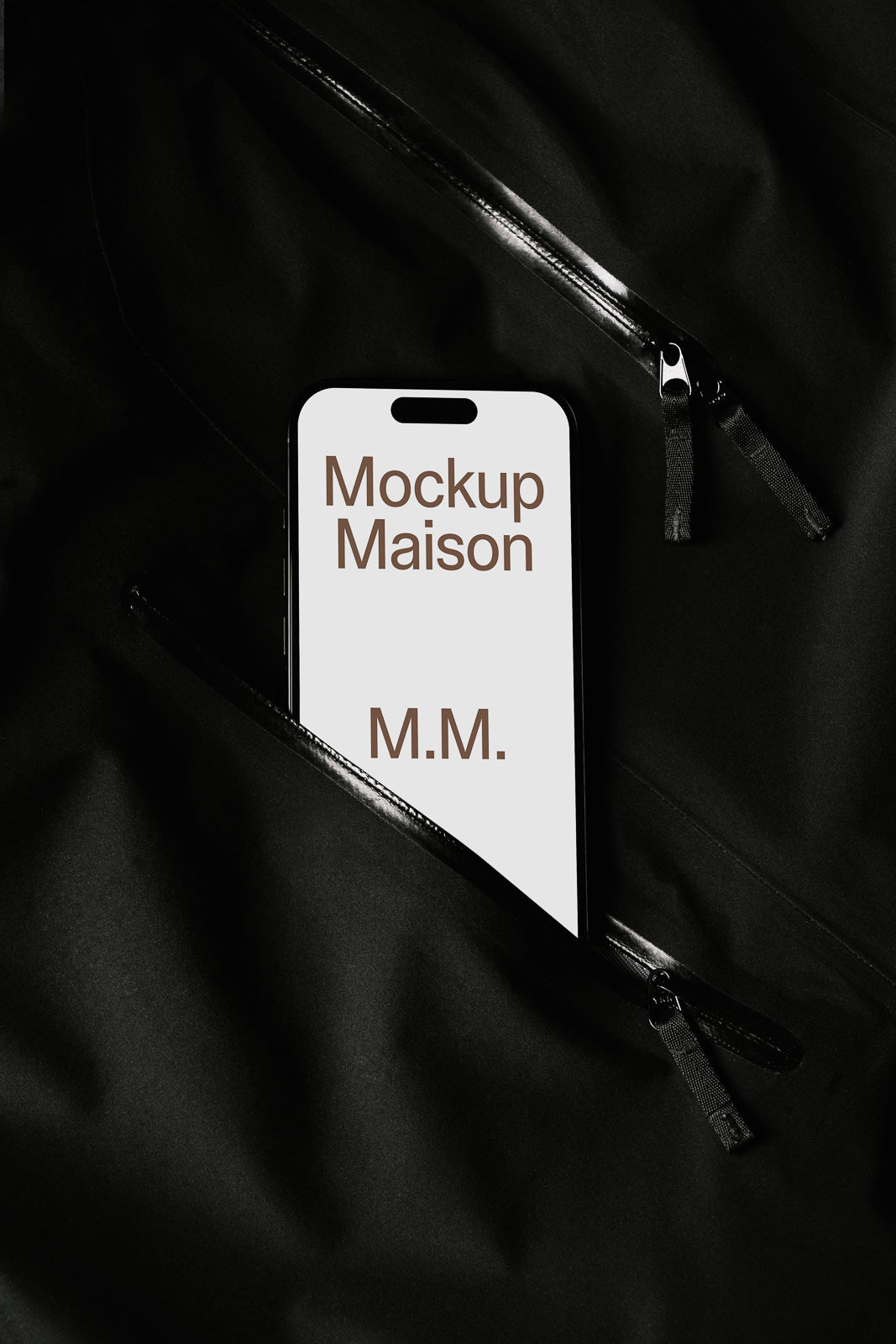 PSD mockup of a smartphone partially tucked into a black fabric pocket displaying the text "Mockup Maison M.M." on its screen.