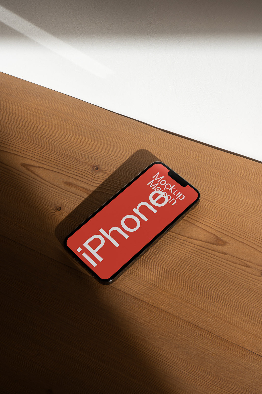 PSD mockup of an iPhone lying on a wooden surface, displaying a red screen with bold white text.