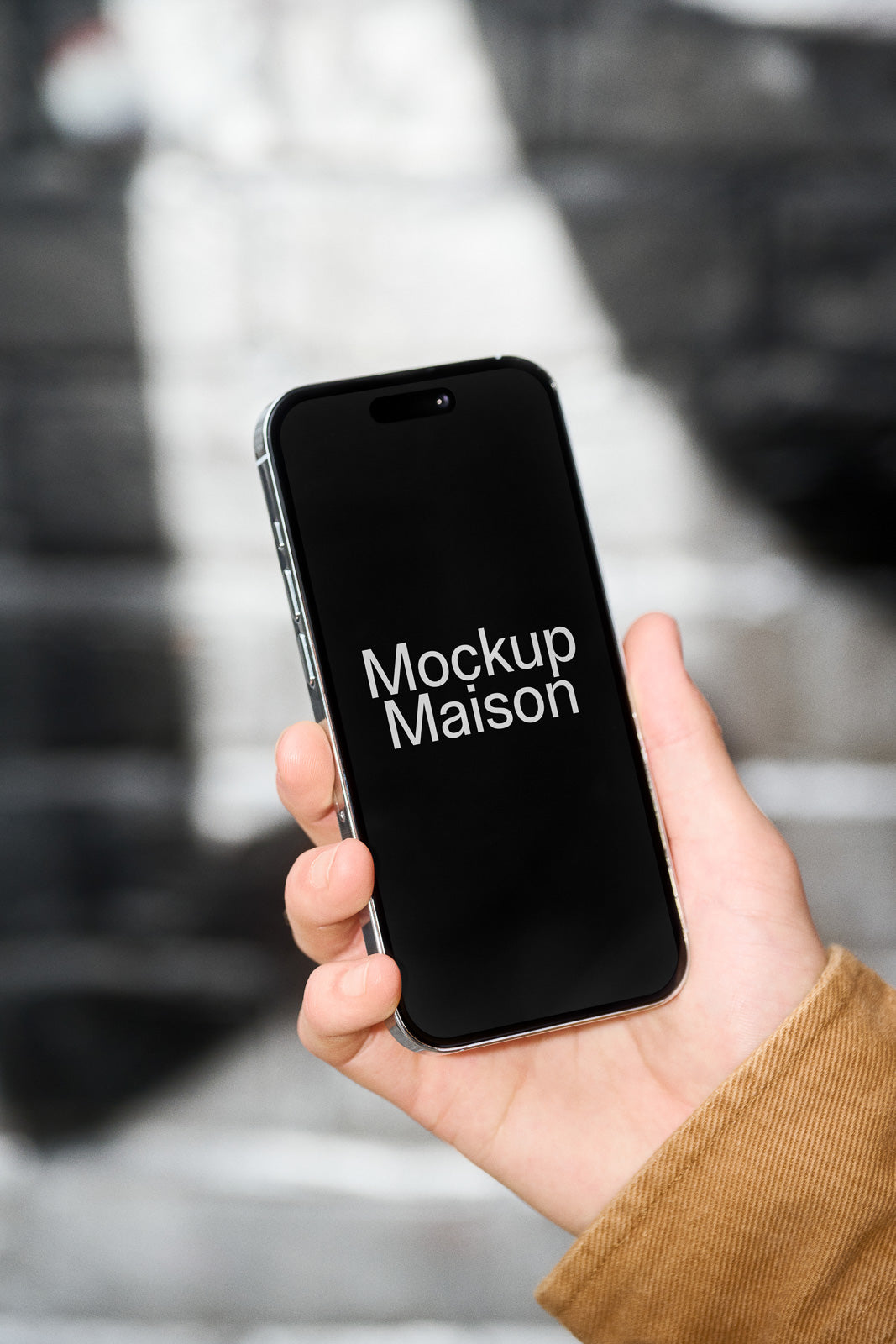 PSD mockup of a hand holding a smartphone with a blank screen against a blurred background, ideal for displaying design layouts.