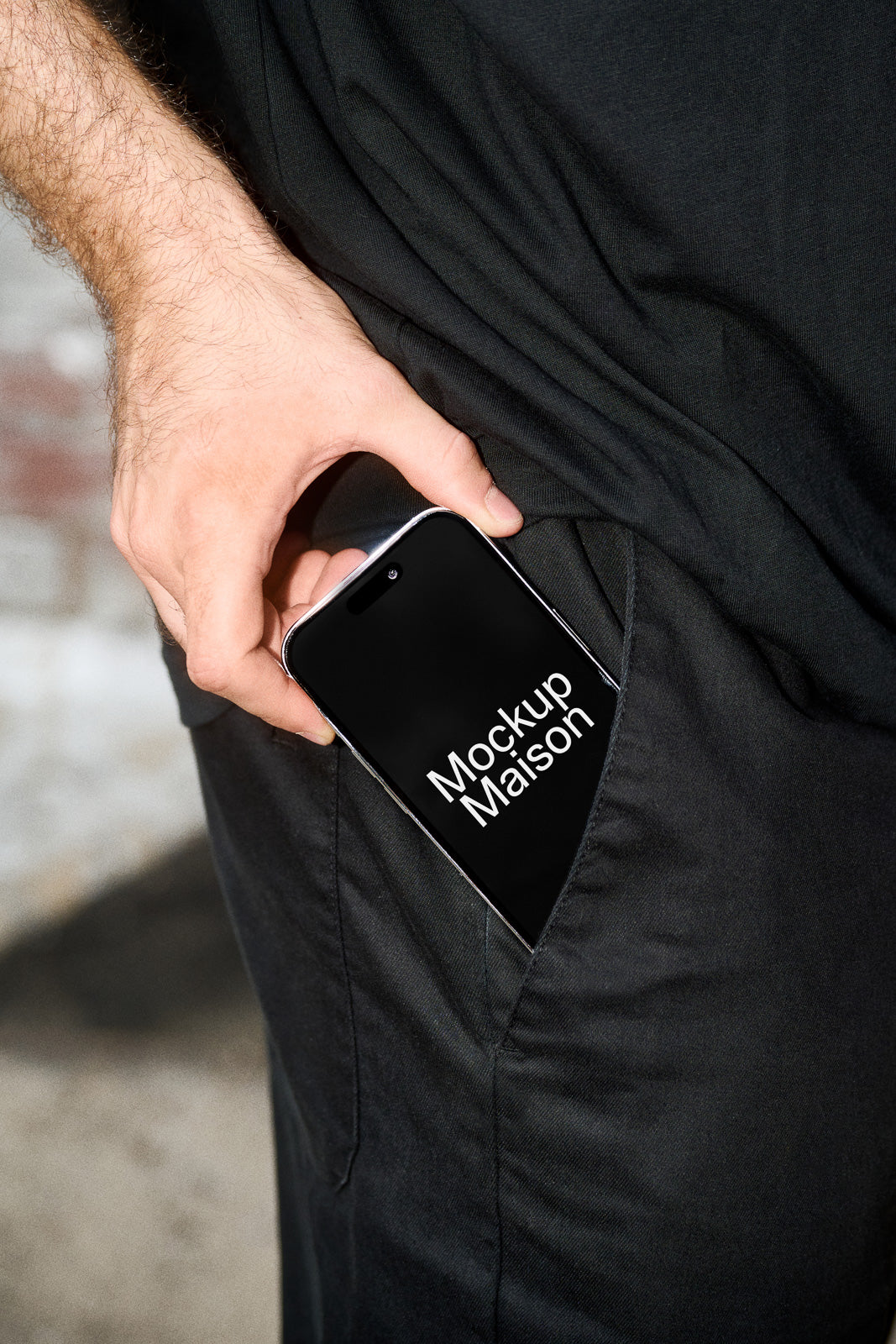 PSD mockup of a smartphone partially tucked into a dark pants pocket, showcasing "Mockup Maison" on the screen.