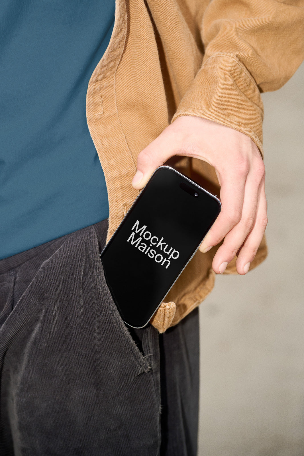 PSD mockup of a smartphone halfway out of a person’s jacket pocket, with "Mockup Maison" displayed on the screen in white text.