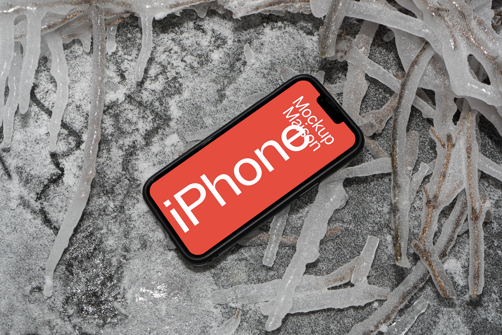 PSD mockup of a smartphone placed on frosty ground with icy branches around, displaying a red screen with white text.