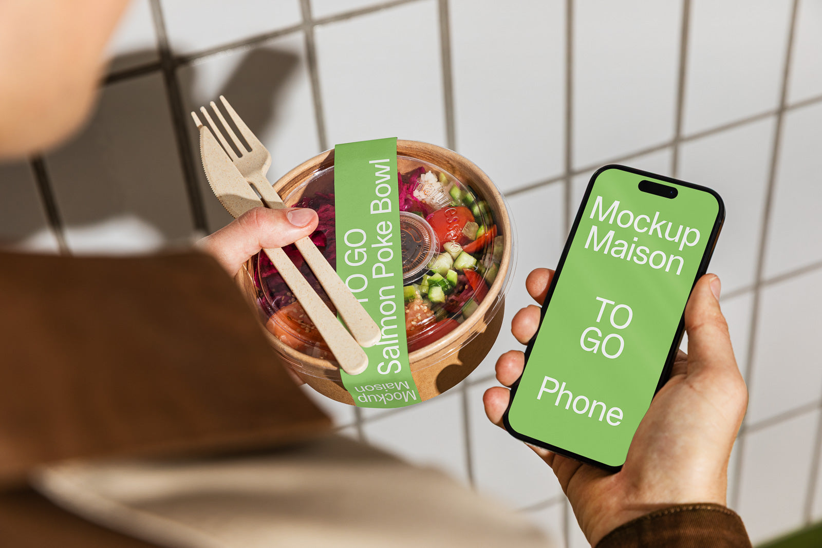 PSD mockup of a person holding a smartphone with a green screen displaying text, alongside a poke bowl labeled "TO GO" with a fork and knife, against a tiled background.