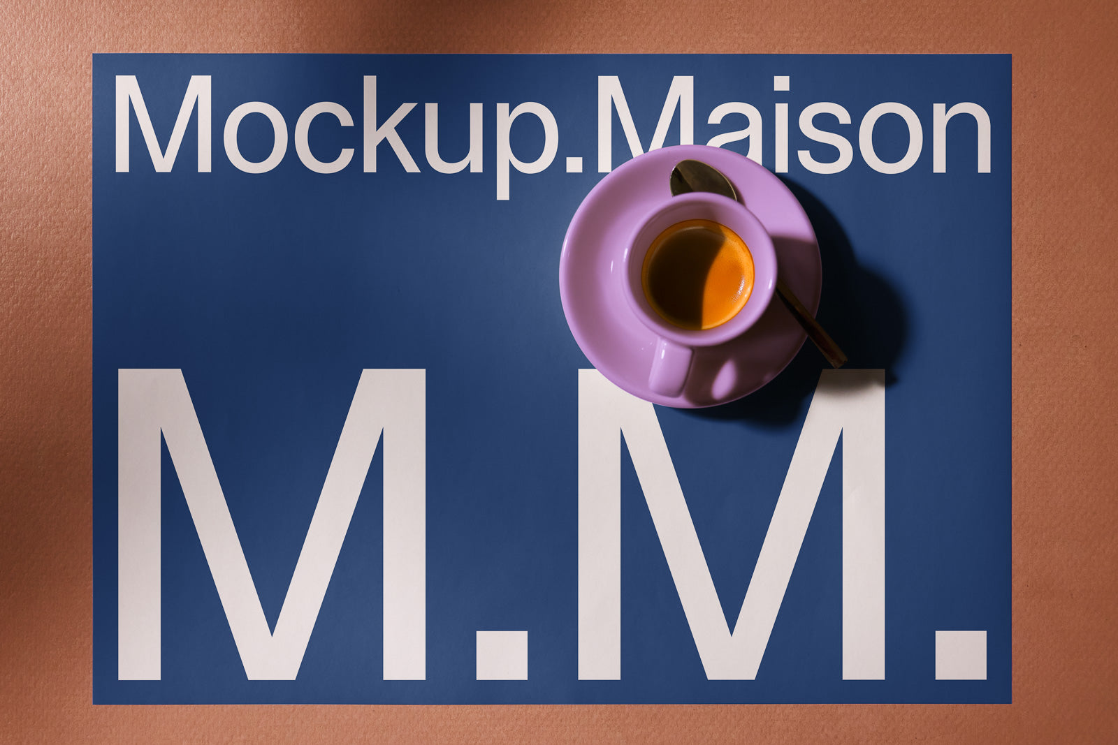 PSD mockup of a blue poster with "Mockup.Maison" and white letters "M.M." on a brown background, featuring a purple cup of coffee on top.