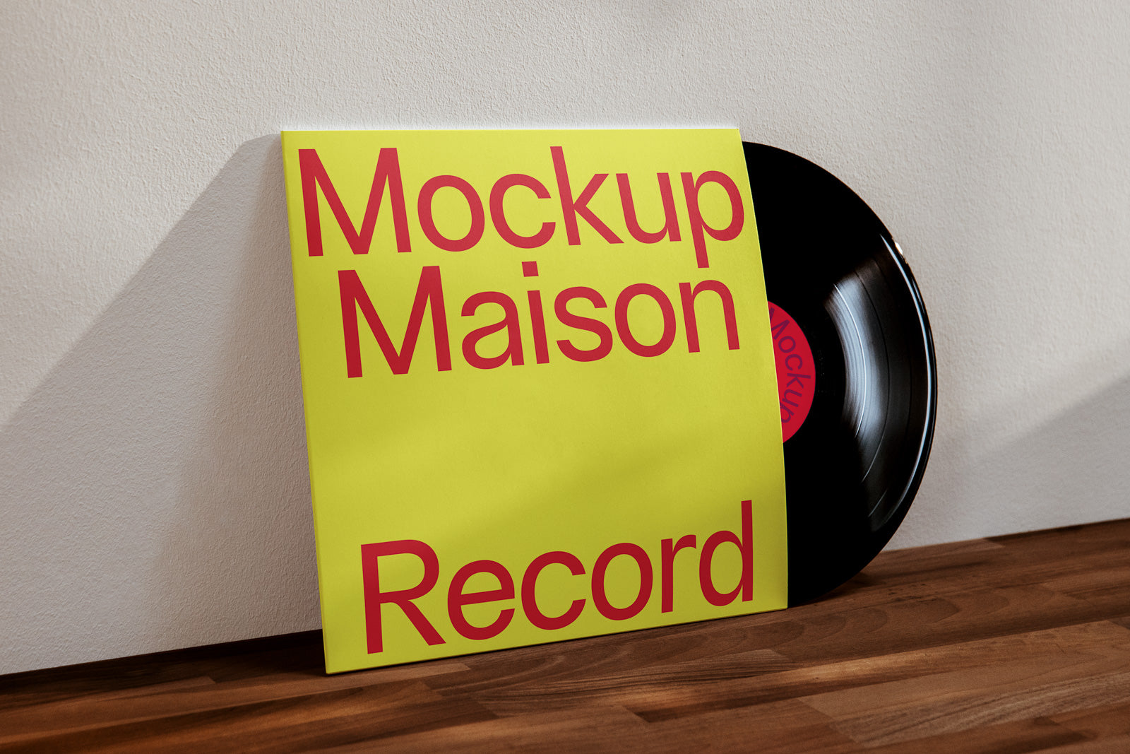 PSD mockup of a vinyl record with a yellow cover featuring bold red text against a light-colored wall and wooden surface.