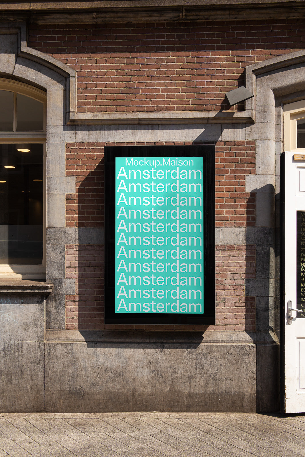 PSD mockup of an outdoor poster on a brick wall displaying the word "Amsterdam" repeatedly in white text on a teal background.