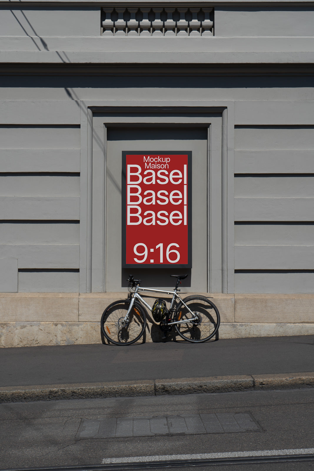 PSD mockup of a wall-mounted red poster with white text "Mockup Maison Basel" and "9:16" beside a parked bicycle on a city sidewalk.