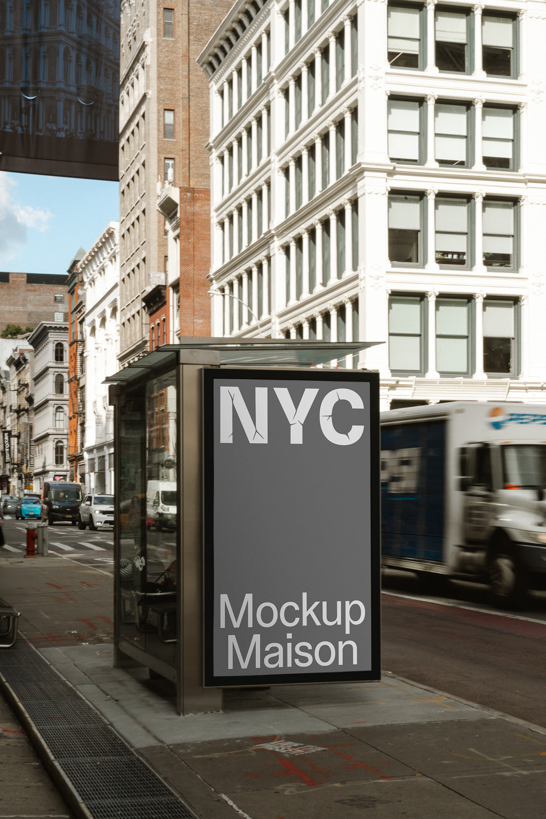PSD mockup of a bus stop advertisement displaying "NYC" and "Mockup Maison" on a city street, with buildings and a truck in the background.
