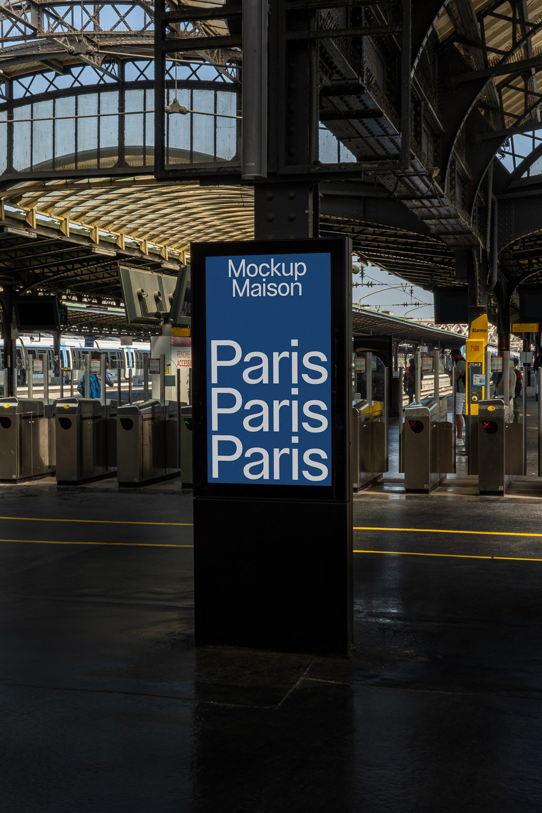 PSD mockup of an outdoor digital sign in a train station displaying "Paris" repeatedly, situated near turnstiles and train platforms.