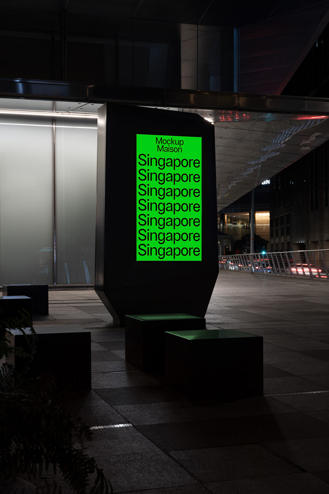 PSD mockup of an illuminated city street advertising display with bold green text repeating “Singapore” under the title “Mockup Maison” at night.