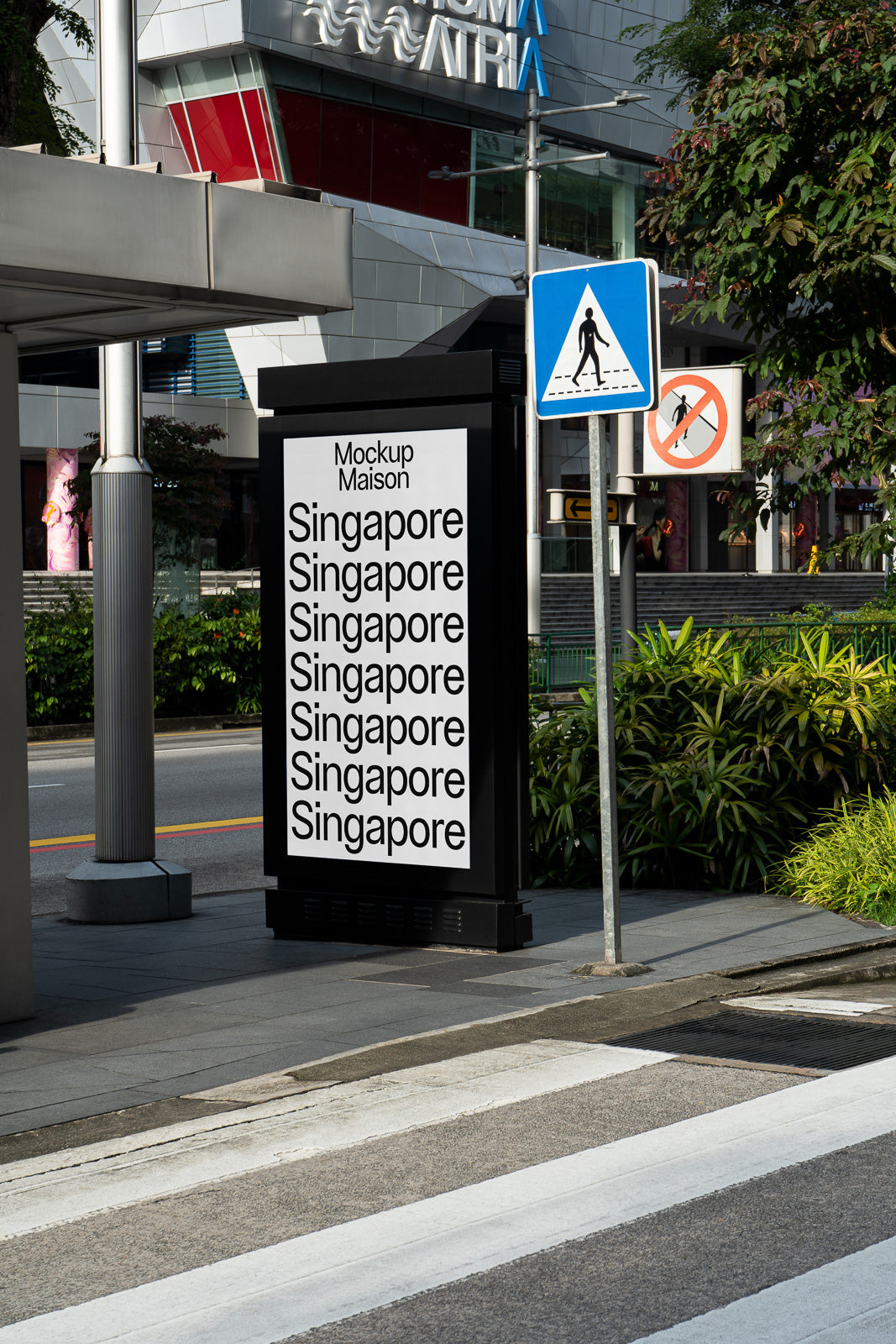 PSD mockup of an outdoor digital billboard displaying "Singapore" with urban surroundings, near a pedestrian crossing and greenery.