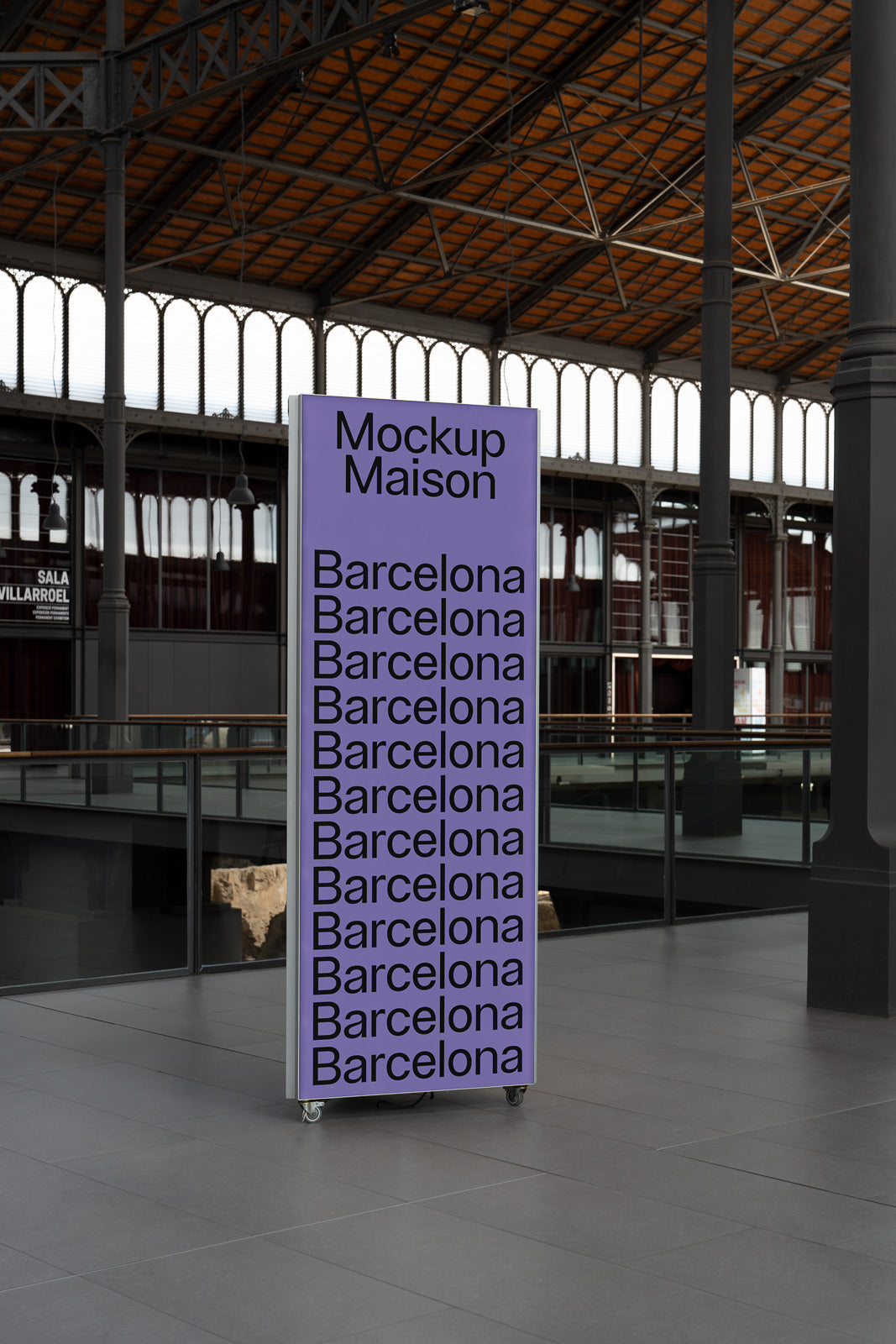 PSD mockup of a vertical display stand featuring repeated text "Barcelona" and "Mockup Maison" on a purple background, set indoors with an industrial ceiling.