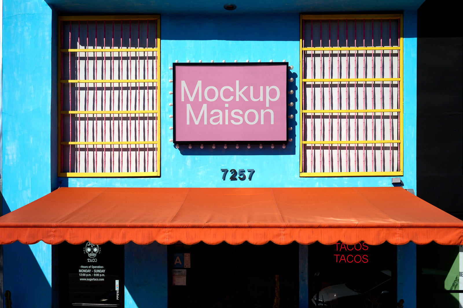 PSD mockup of a colorful storefront with a pink sign reading "Mockup Maison" against a bright blue wall, featuring an orange awning.