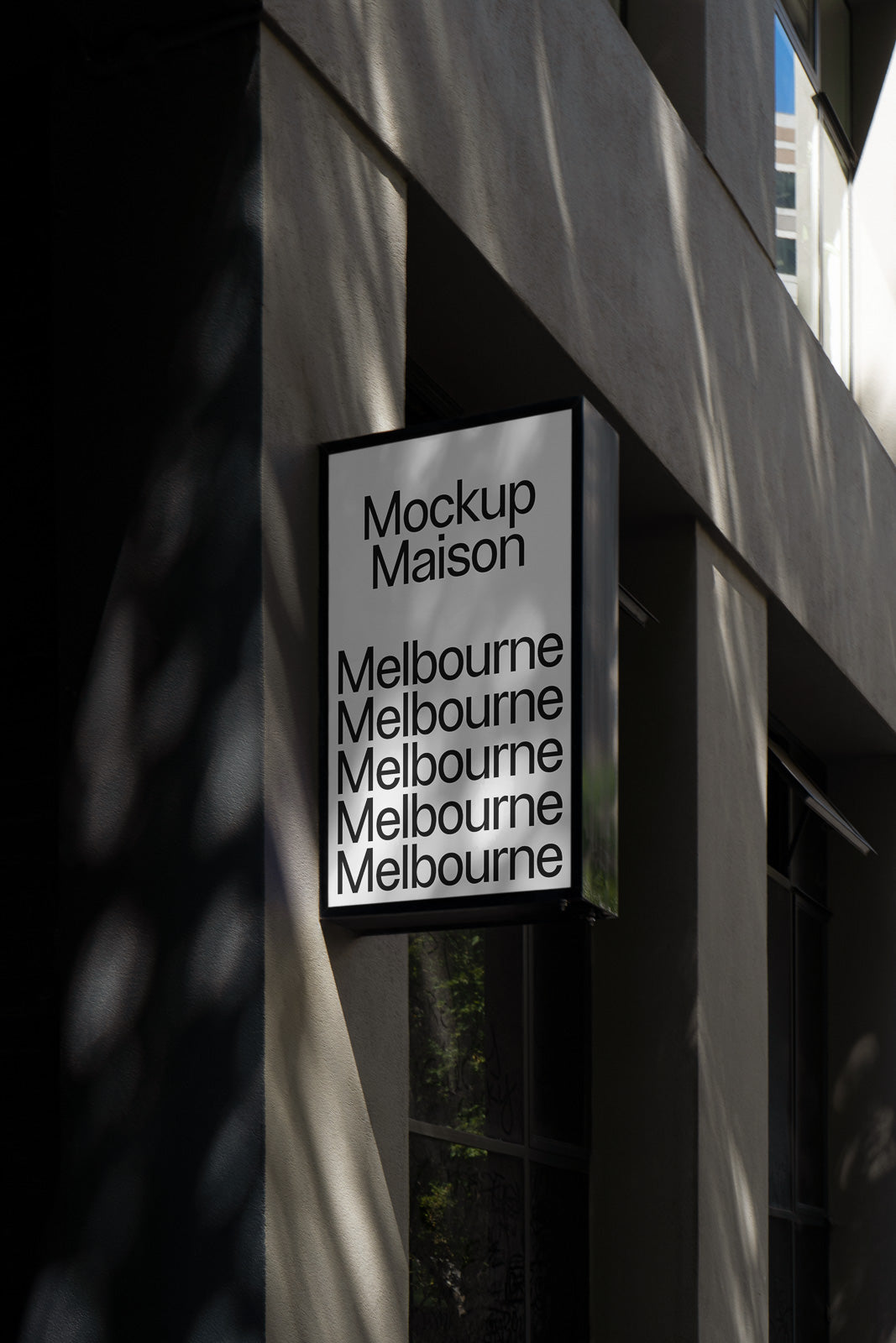 PSD mockup of a building facade sign displaying the words "Mockup Maison" with "Melbourne" repeated multiple times, set against a modern concrete wall.