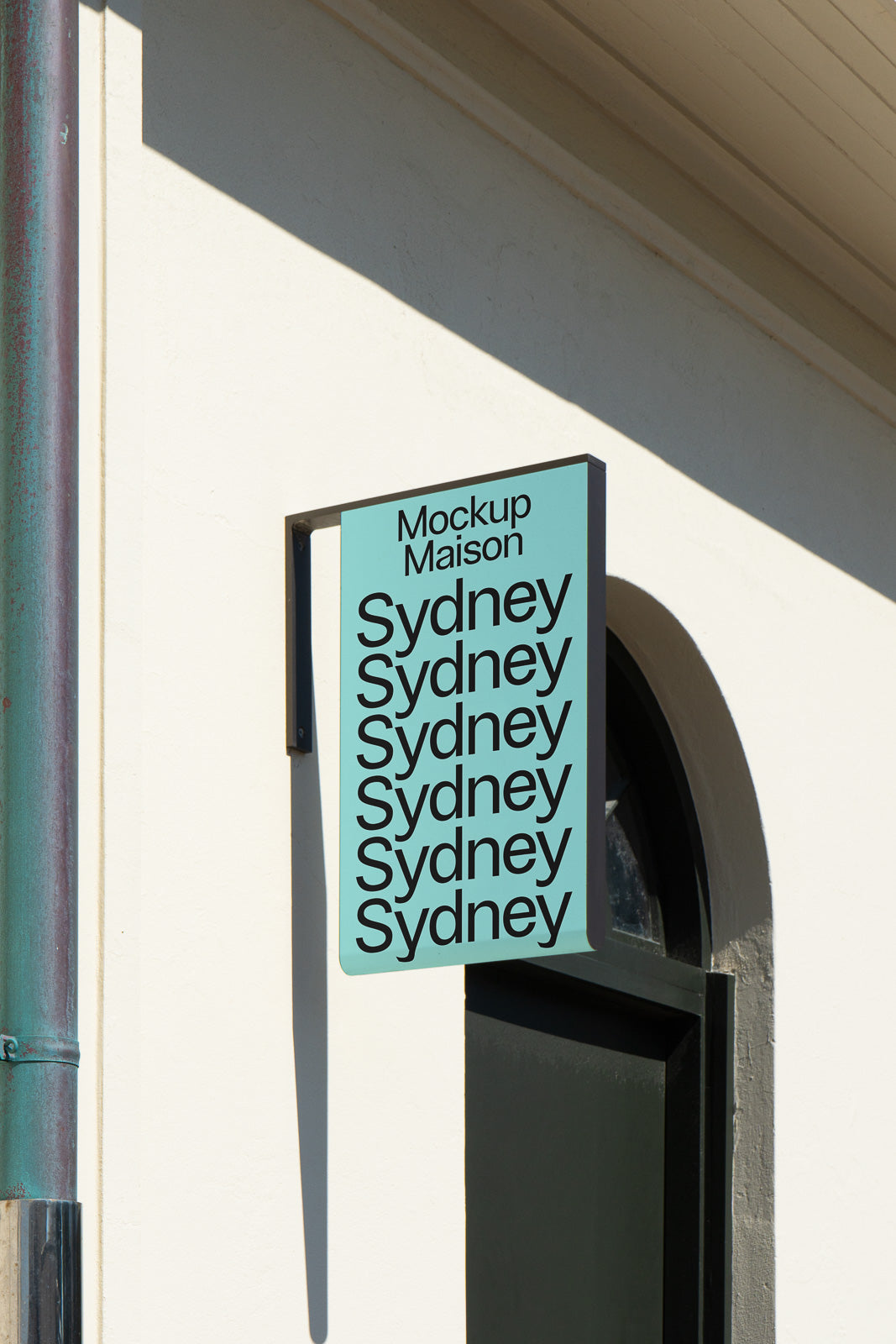 PSD mockup of a vertical rectangular shop sign attached to a building wall, featuring repetitive text display of "Sydney" in bold black font on a light blue background.