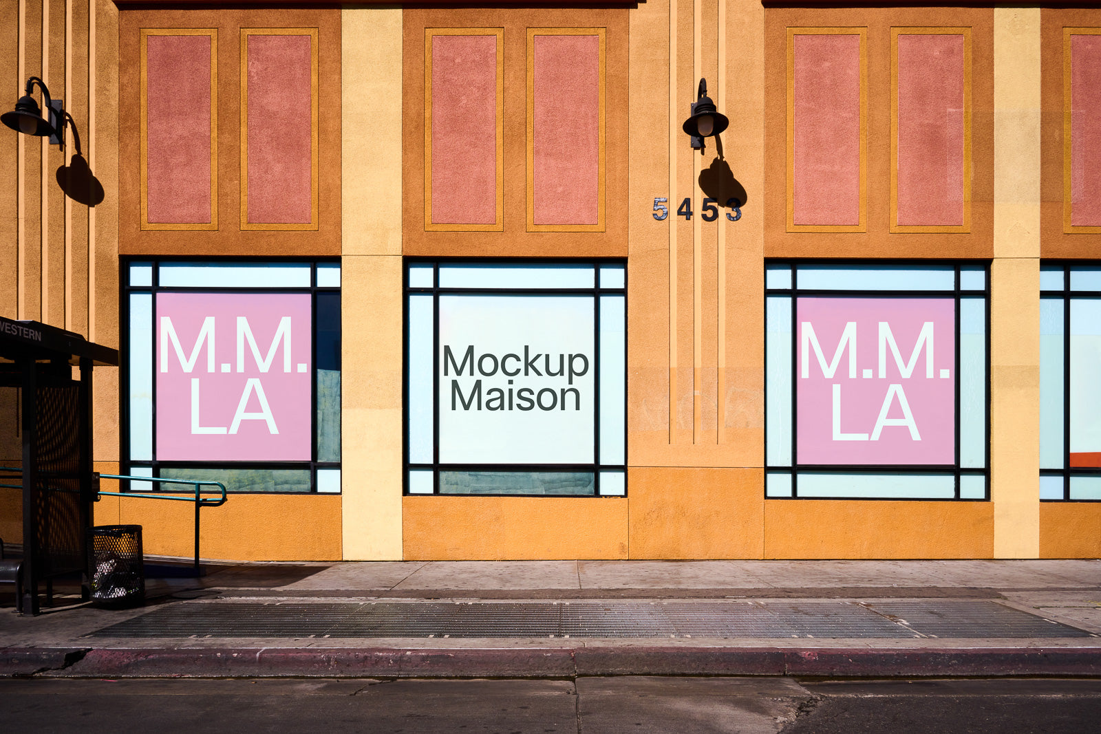 PSD mockup of a storefront window displaying "Mockup Maison" centered with "M.M. LA" on adjacent windows in pastel pink, set against a textured wall.