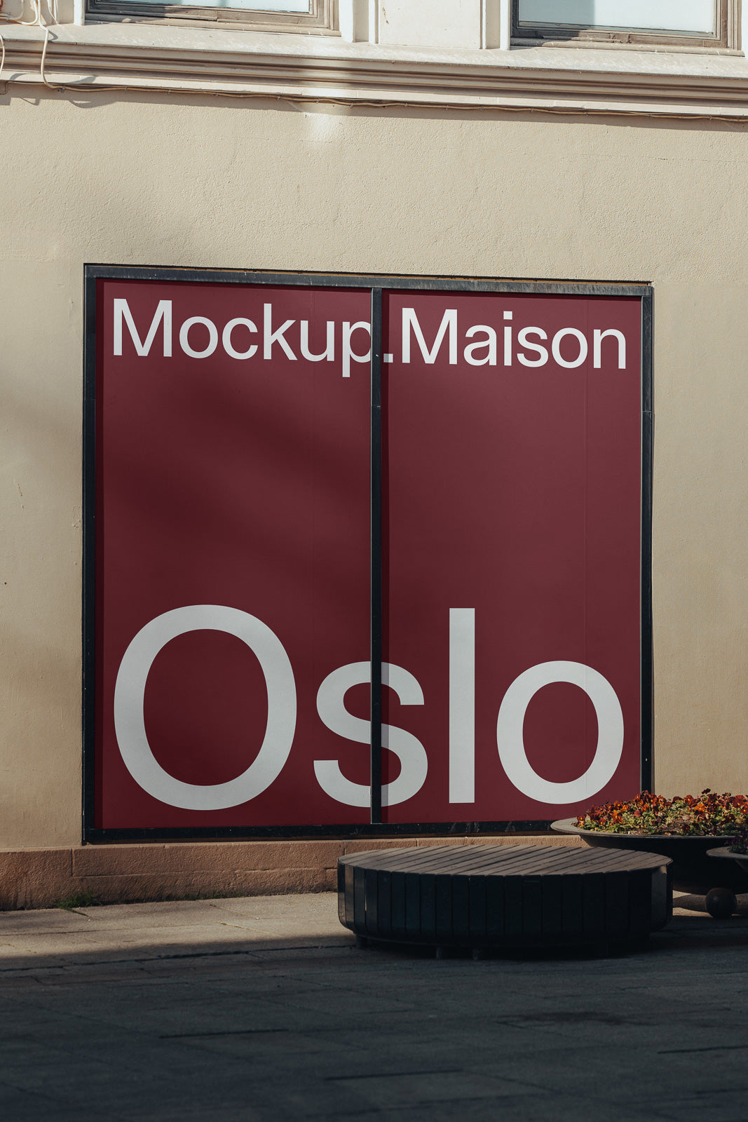 PSD mockup of a large red storefront display with white text "Mockup.Maison Oslo," set against a beige wall, next to a planter with flowers.