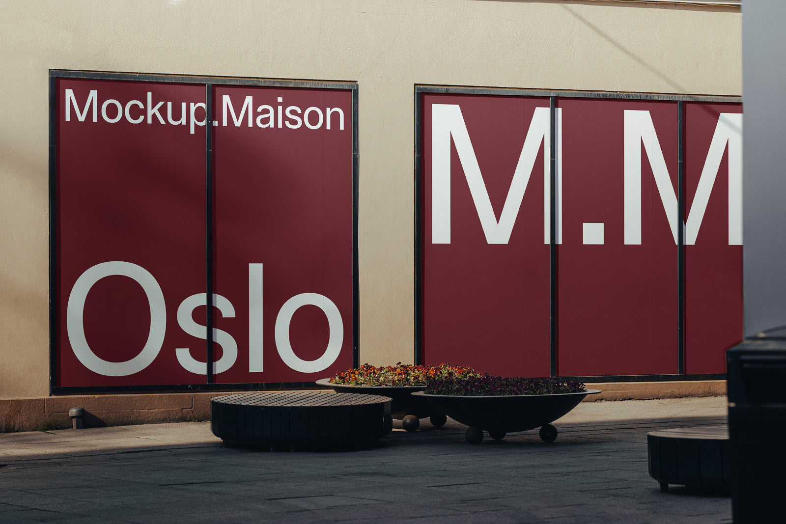 PSD mockup of large red wall with white text "Mockup.Maison, Oslo" featuring modern planters and benches in foreground.