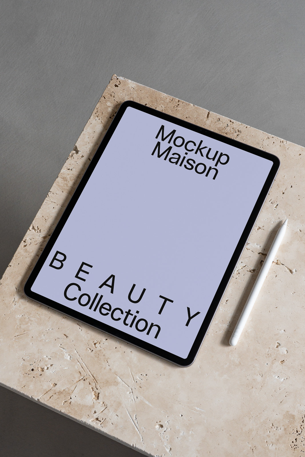 PSD mockup of a tablet on a textured stone surface with a stylus nearby. The screen displays "Mockup Maison Beauty Collection" in bold text.