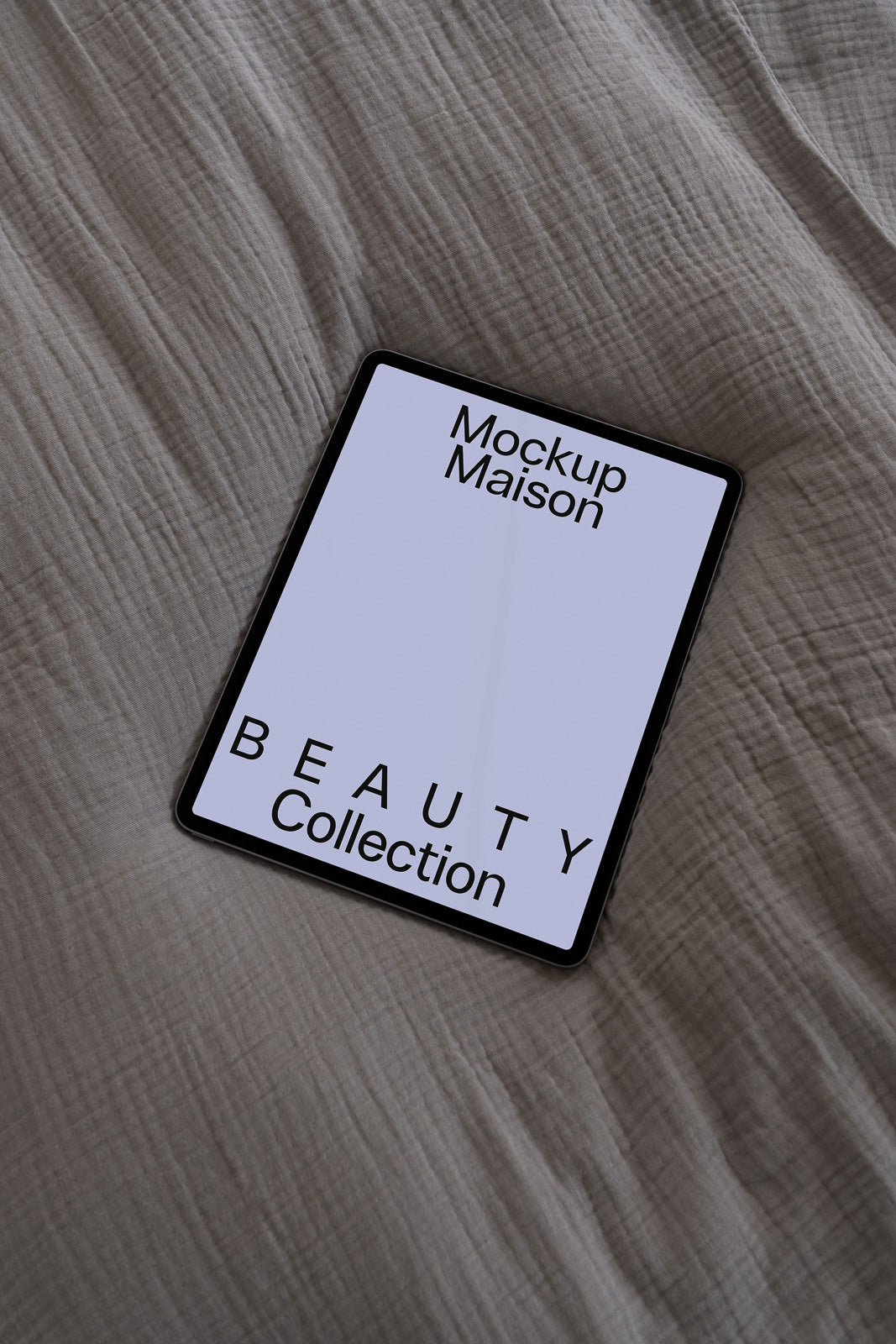 PSD mockup of a tablet displaying "Mockup Maison" and "Beauty Collection" on a textured fabric surface.