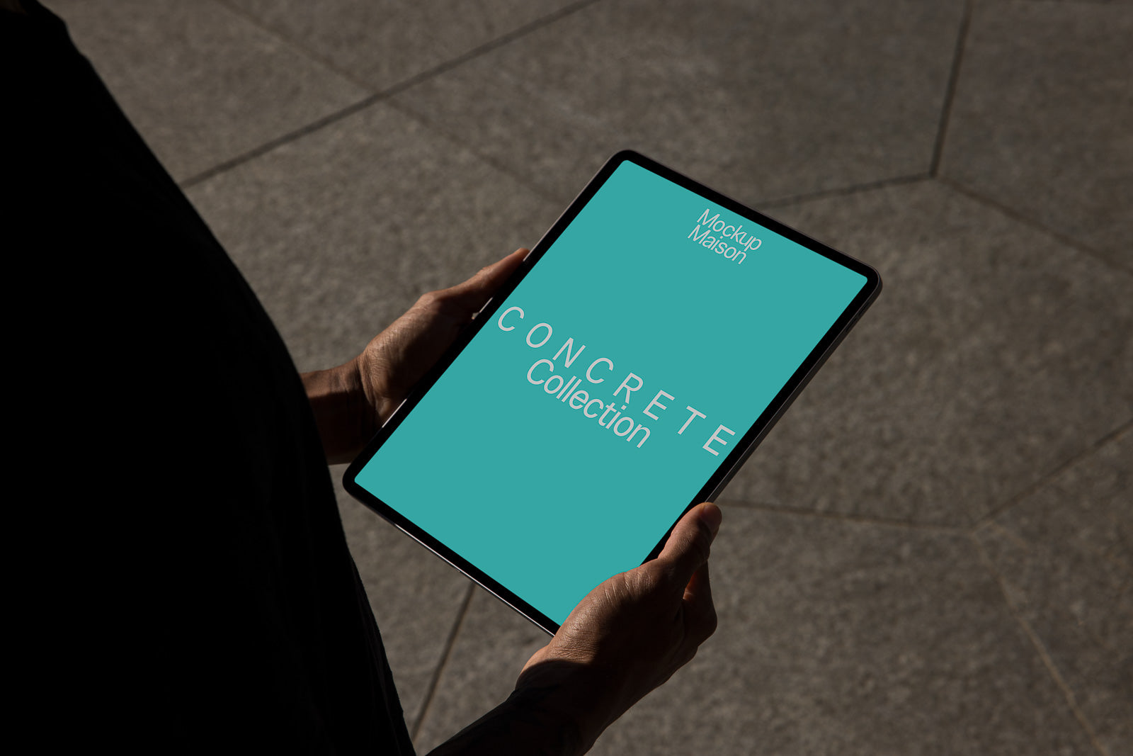 PSD mockup of a tablet being held by a person, displaying "CONCRETE Collection" on a teal background, suitable for branding visualization.