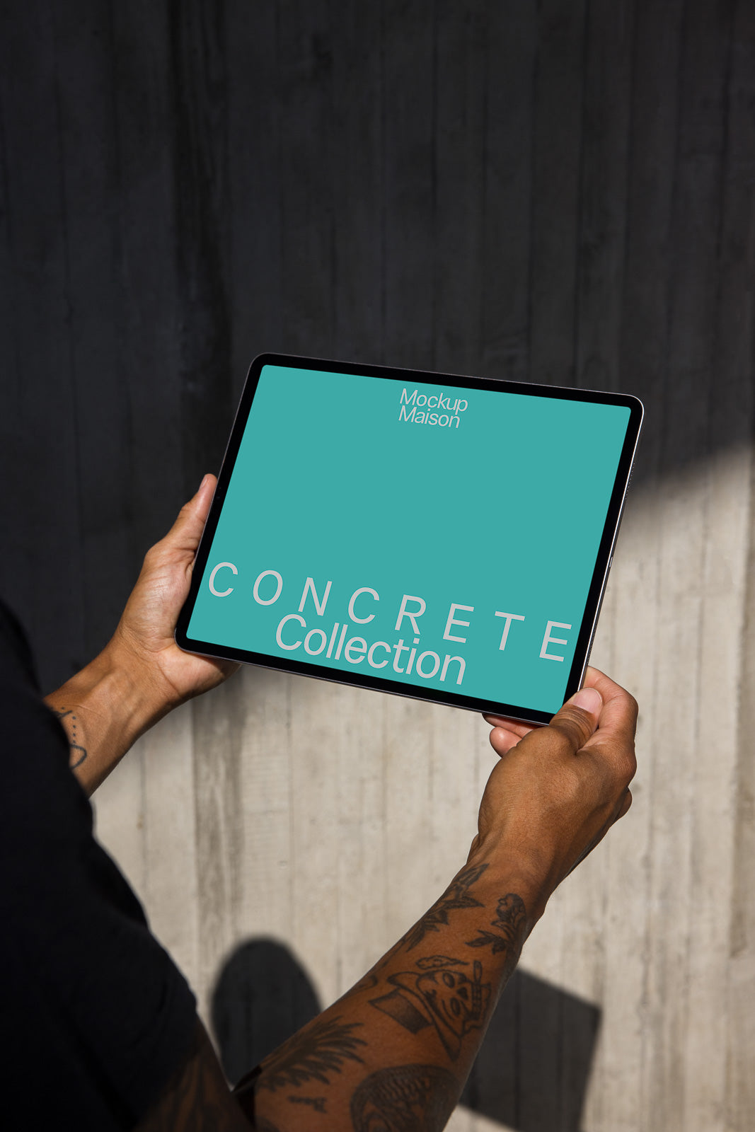 PSD mockup of a person holding a tablet displaying a turquoise screen with the text "CONCRETE Collection" and "Mockup Maison" against a concrete wall background.