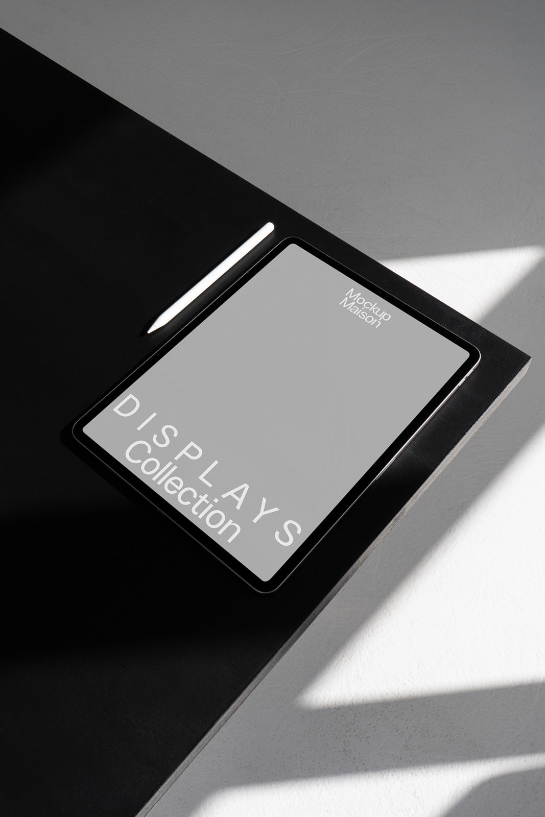 PSD mockup of a tablet on a black surface with a stylus, showcasing the phrase "DISPLAYS Collection" on the screen, under natural lighting.