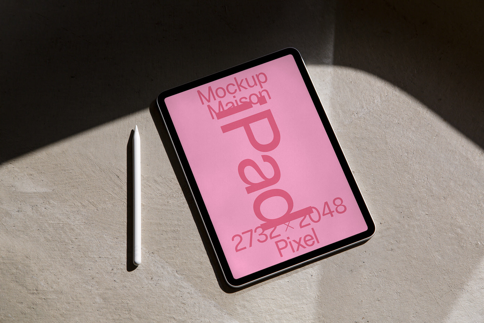 PSD mockup of a tablet with a pink screen displaying "Pad" and pixel dimensions 2732x2048, beside a white stylus on a textured surface.