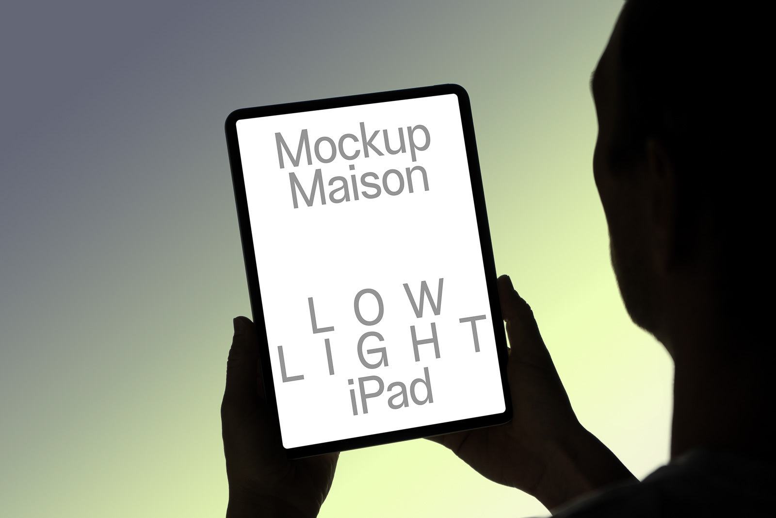 PSD mockup of a person holding a tablet displaying "Mockup Maison Low Light iPad" text against a gradient background.