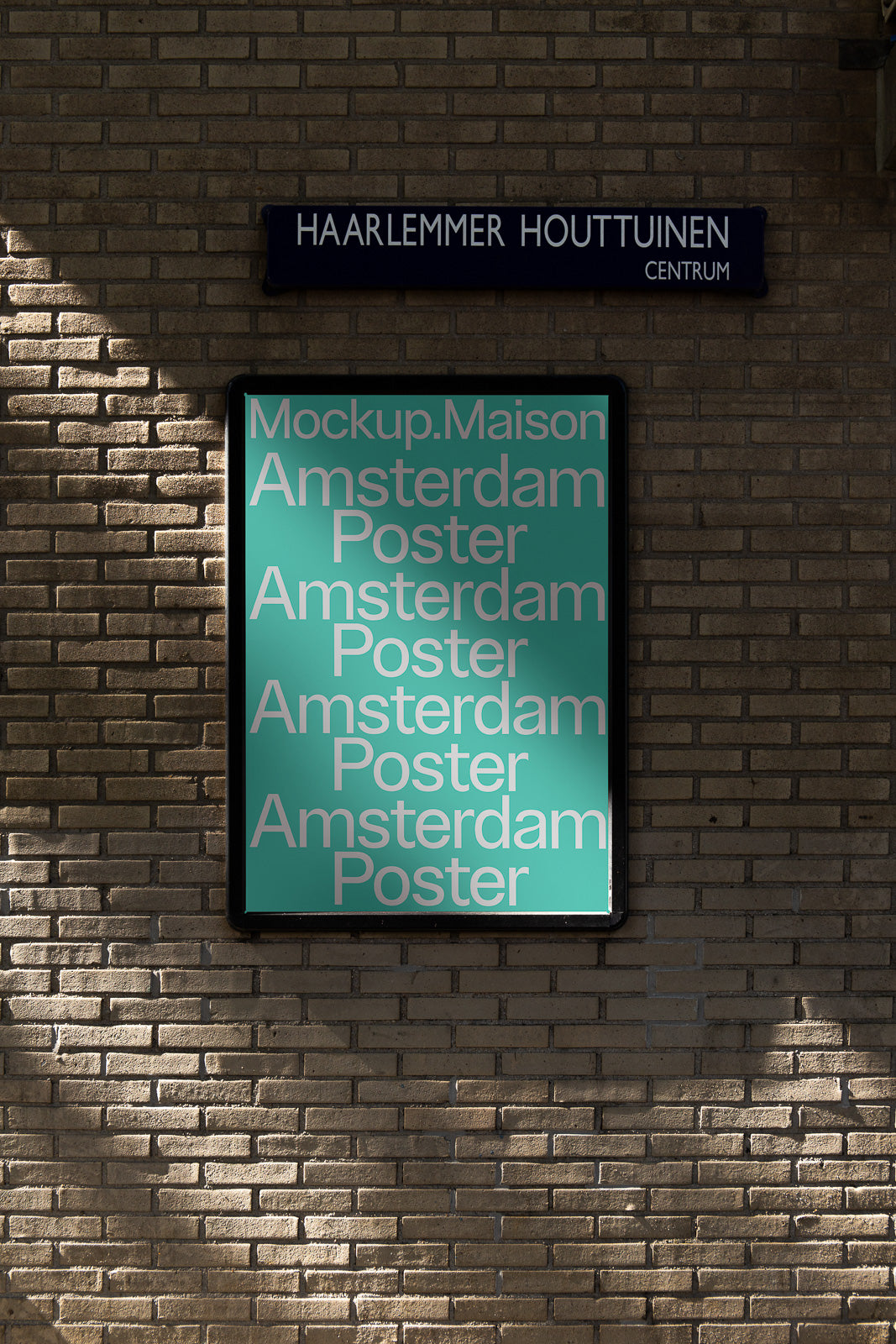 PSD mockup of a poster with "Amsterdam Poster" repeated multiple times on a teal background, displayed on a brick wall under a street sign.