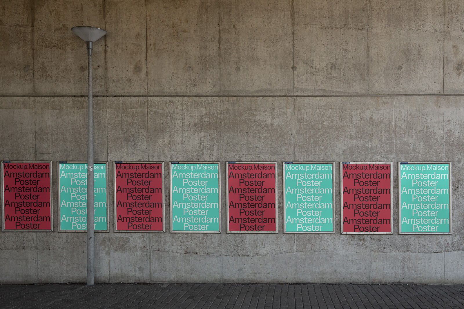 PSD mockup of a series of colorful "Amsterdam Poster" designs displayed on an urban concrete wall, slightly obscured by a pole.