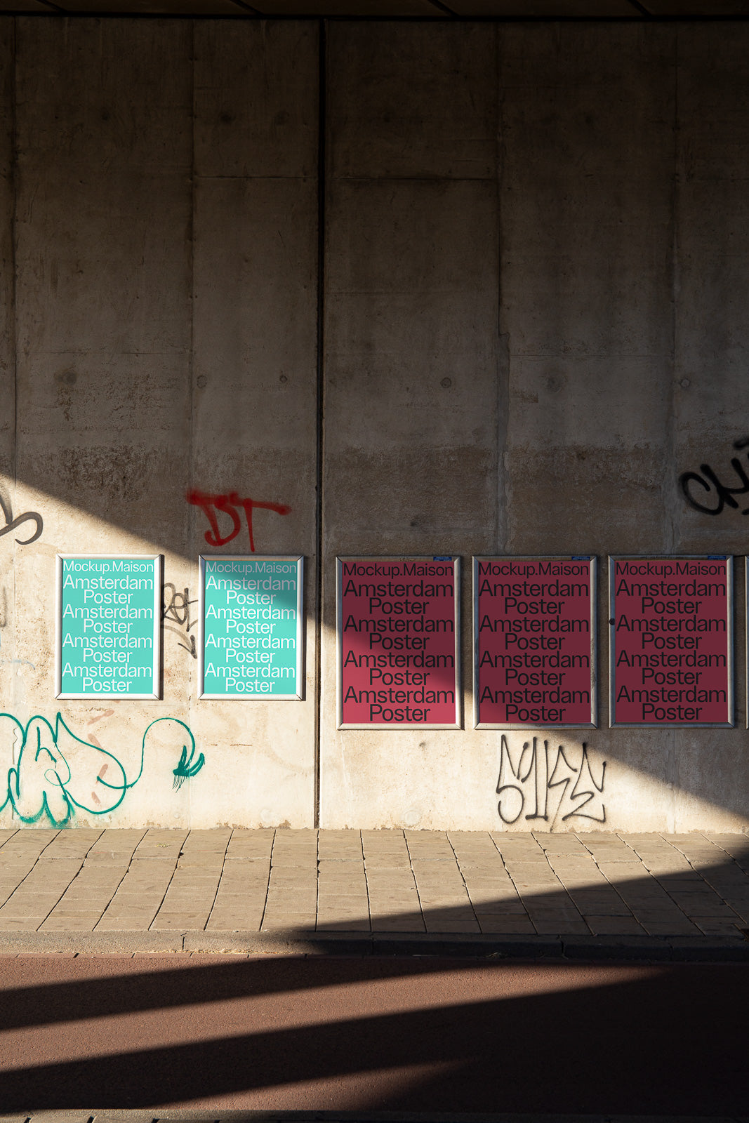 PSD mockup of posters displayed on a concrete wall, showcasing variations in color and design, with surrounding street art and shadows.