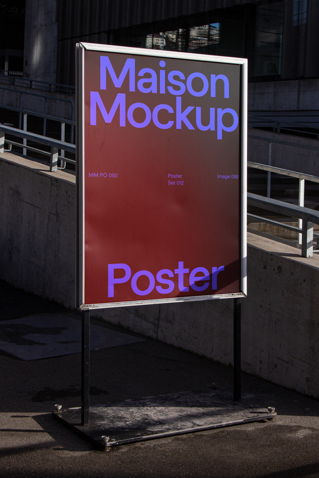 PSD mockup of an outdoor poster stand featuring a design with text "Maison Mockup" and "Poster" in bold blue on a red background, set against an urban environment.