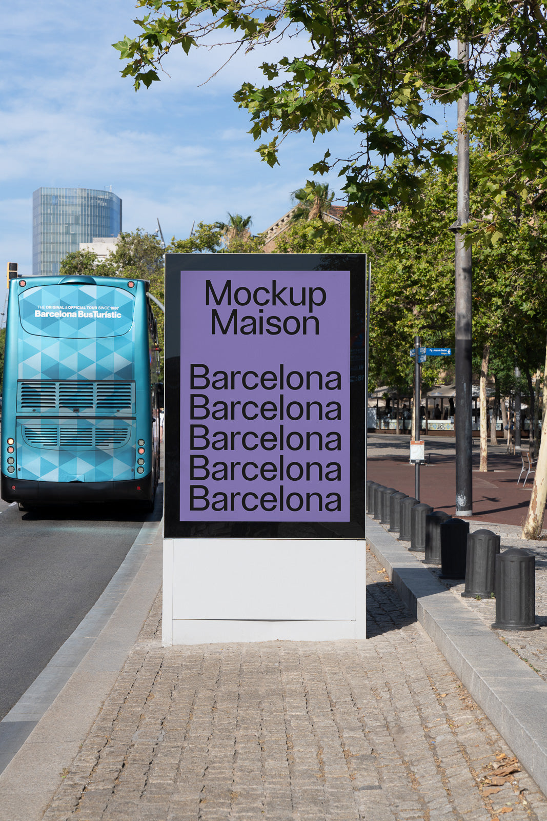PSD mockup of a city street billboard displaying "Mockup Maison Barcelona" multiple times in front of a tour bus, with trees and a building in the background.