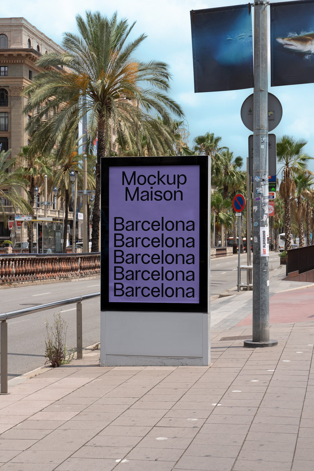 PSD mockup of an outdoor advertising display on a city sidewalk, featuring repetitive text "Barcelona" under "Mockup Maison" with palm trees in the background.