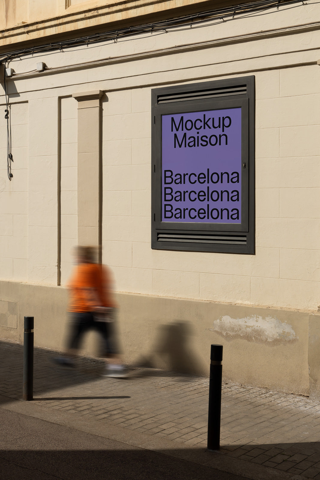 PSD mockup of a building wall featuring a framed poster with text that reads "Mockup Maison" and "Barcelona" repeated three times.