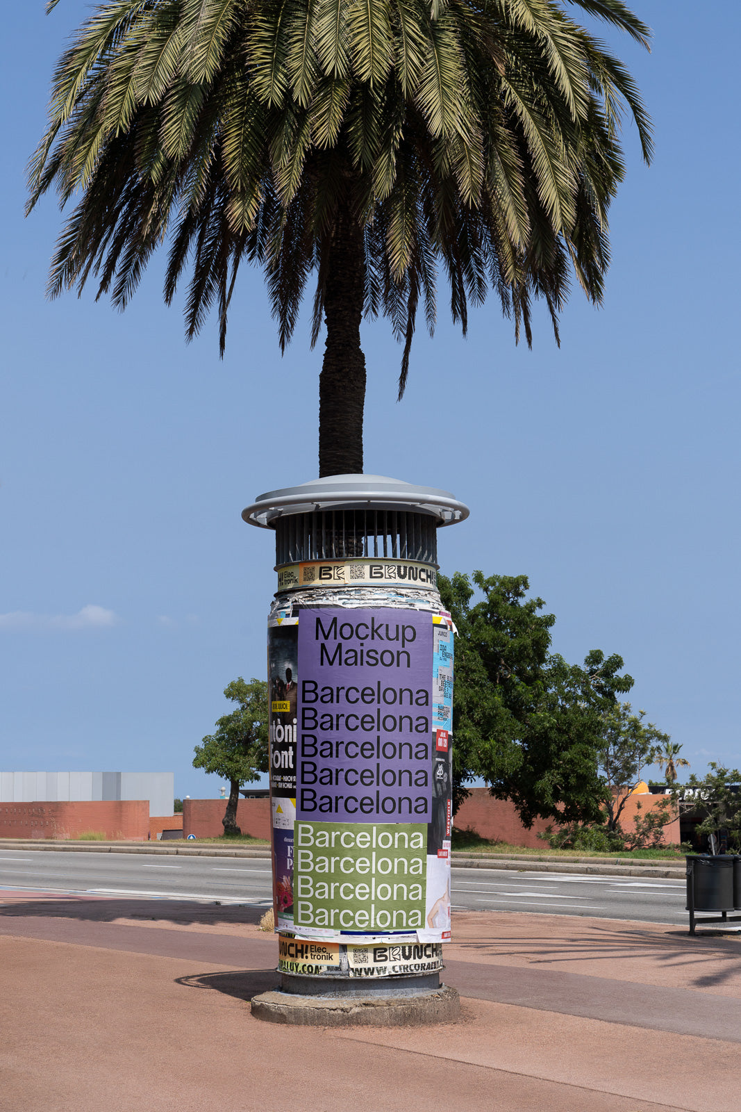 PSD mockup of a cylindrical advertising pillar with various posters, set against a backdrop of a palm tree and a clear blue sky.