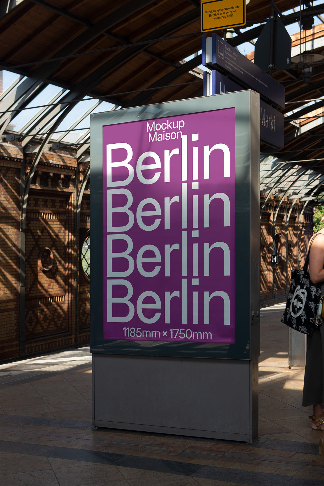 PSD mockup of a vertical poster on a train station platform featuring repeated text "Berlin" in white on a purple background with dimensions 1185mm x 1750mm.
