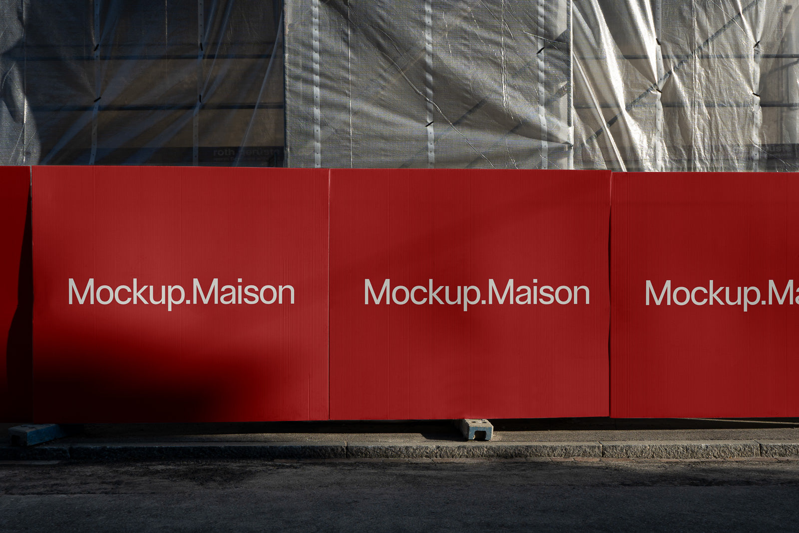 PSD mockup of a construction site barrier with "Mockup.Maison" printed in white on vibrant red panels.
