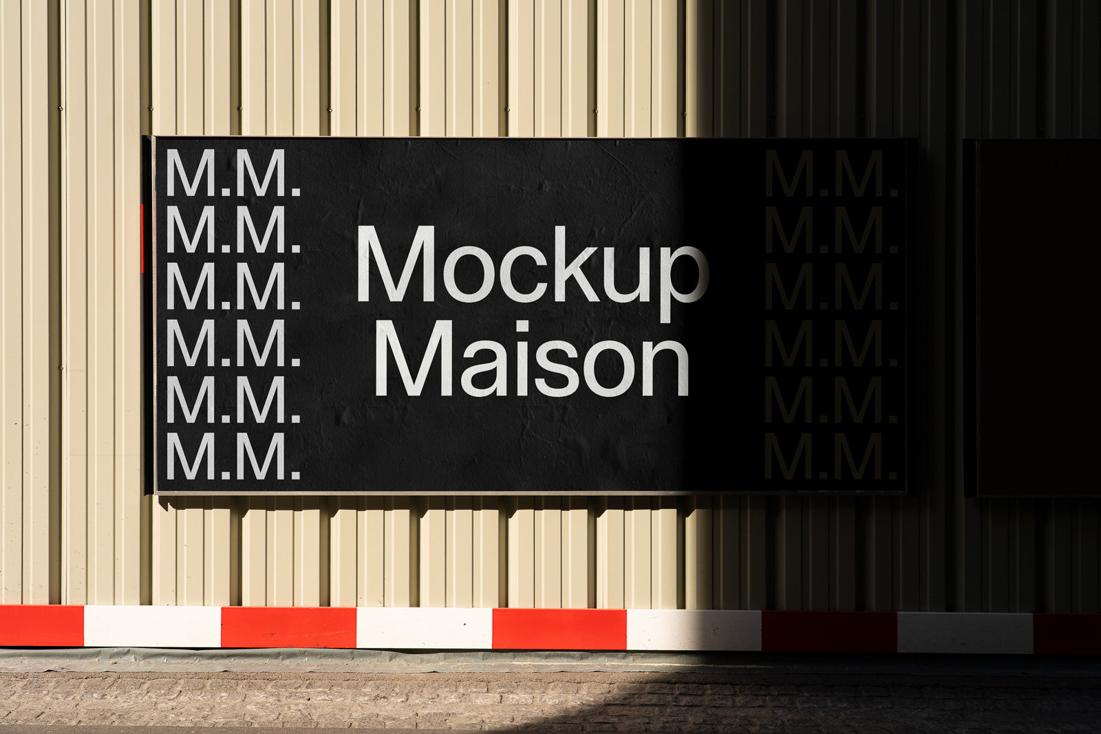 PSD mockup of a black signboard with "Mockup Maison" and repeating "M.M." pattern against a beige corrugated wall, partially in shadow.